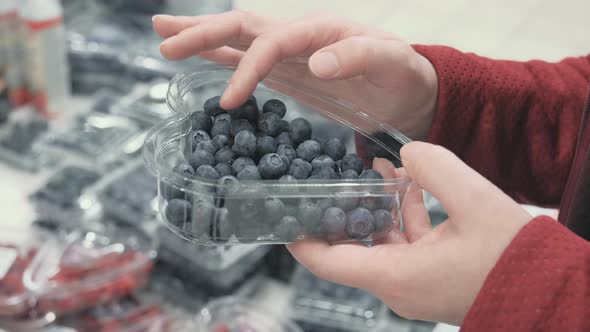 Woman Choose Fresh Bilberry in a Shop alt