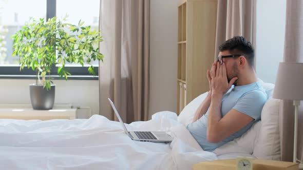 Man in Glasses with Laptop Getting Out From Bed