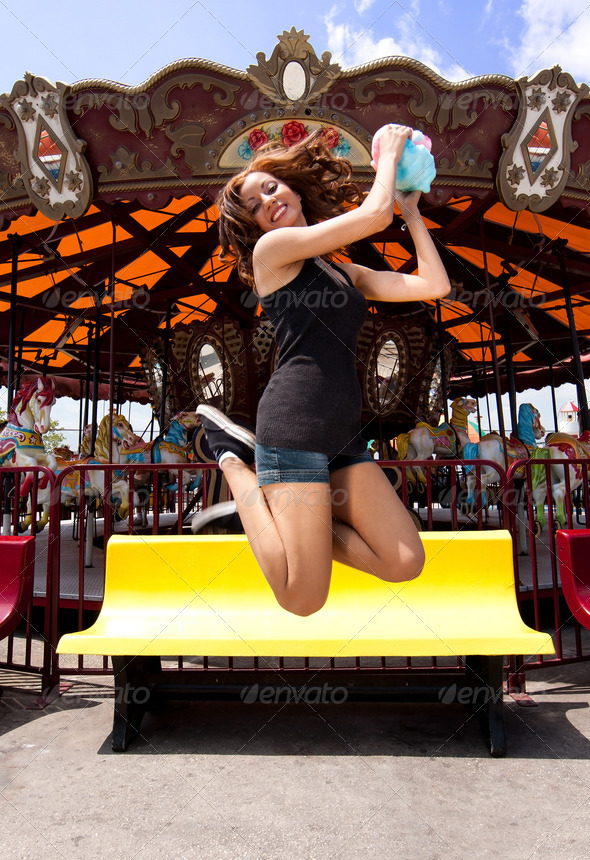 Fun girl jumping at Carousel - Stock Photo - Images