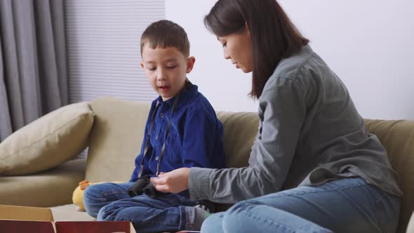 Handsome Asian mother and son playing a game and talking alt