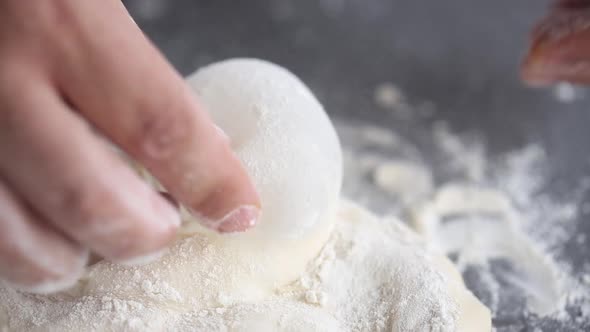 Baker kneads the dough with his fingers, close up