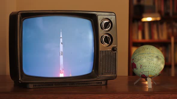 Color Footage of the 1969 Apollo 11 Launch on a Retro TV near a Globe Map. 4K Version.