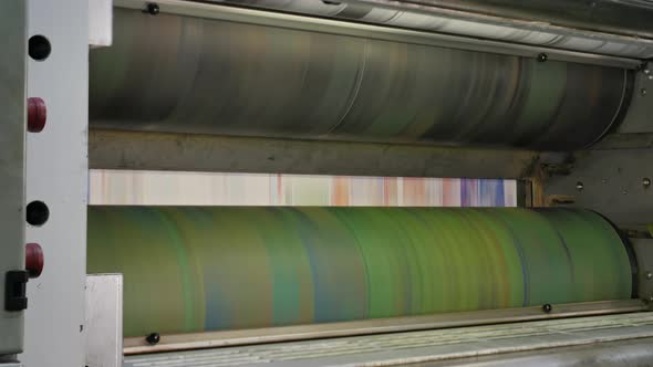 Ink rollers at high speed in a printing factory printing newspapers alt