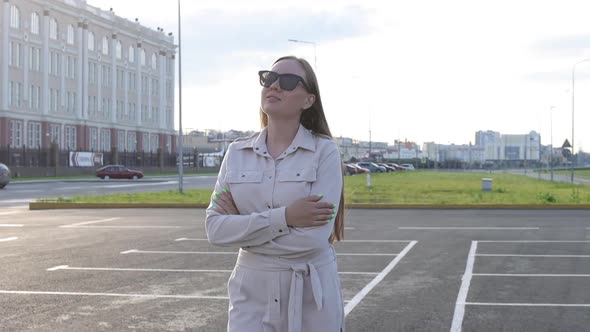 Beautiful Young Girl with Glasses Walks Through the City and Looks Around