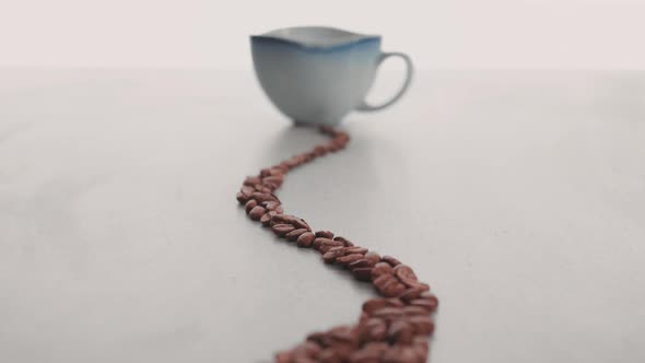 Coffee beans and cup in the making of a cup of coffee 4 alt