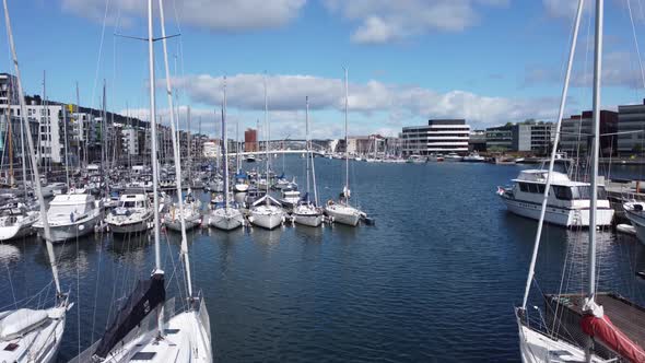 Flying over huge anchor statue and over sailing boat masts to reveal Solheimsviken with puddefjord b alt