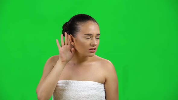 Woman in White Towel Does Not Hear Anything, Shows His Hands Emotions Isolated on Green Screen at alt