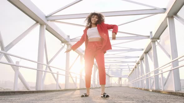 Happy beautiful afro-american woman walking and dancing outdoor