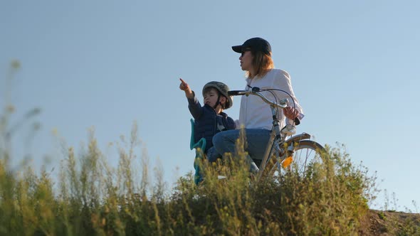 Mom with a Little Son with a Bike on Top, Look Around alt