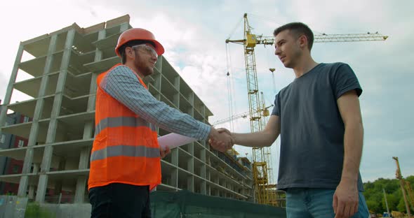 Man Architects Engineers and Male Client Shaking Hands at Construction Site. Professions alt
