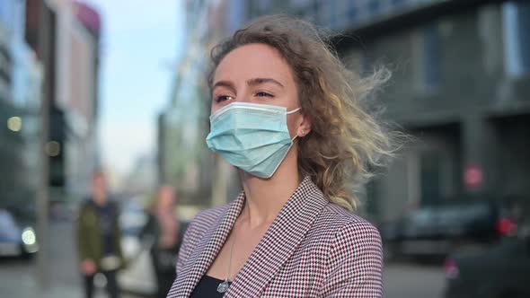 Close-up of a young woman in a jacket and a medical mask. Office worker alt