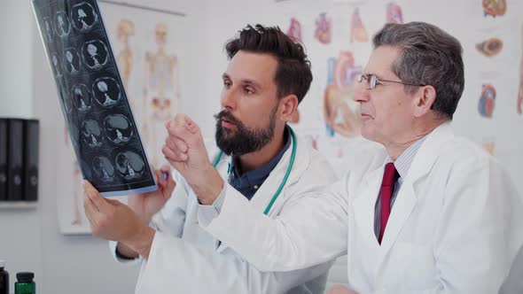 Handheld view of two busy doctors discussing some medical records. Shot with RED helium camera in 8K alt