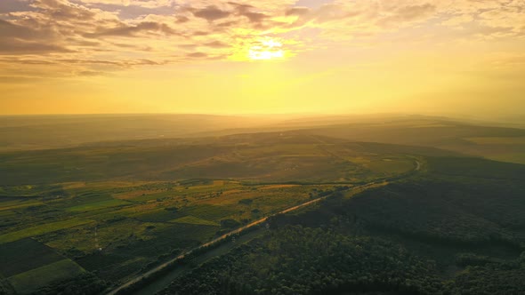 Aerial drone view of nature in Moldova at sunset. Highway, wide fields and hills, forest alt