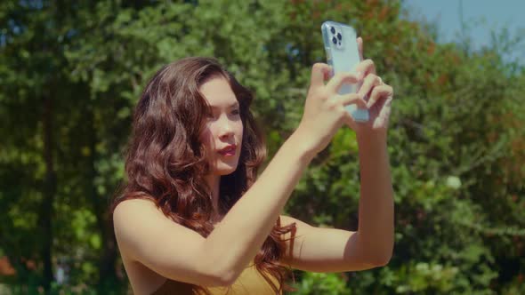 Asian Girl Photographing Landscape in Park Closeup alt