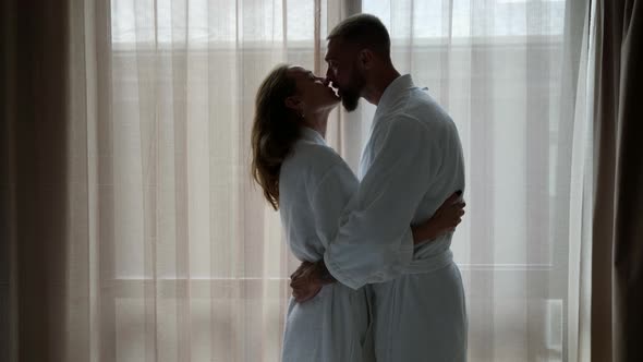 Loving Man and Woman are Hugging in Morning in Bedroom Against Window alt