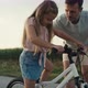 Caucasian Father teaching his little daughter how to ride a bike. Shot with RED helium camera in 8K. - VideoHive Item for Sale