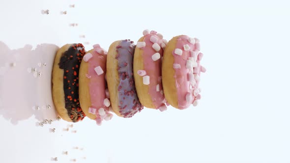 Vertical Video of Five Sweet Doughnuts Stacked on Top of Each Other in the Form of Tower