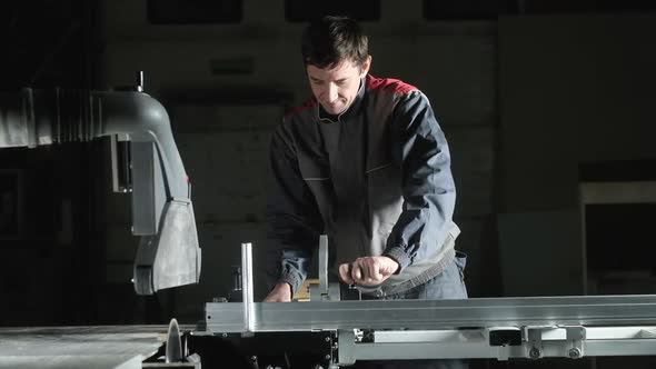 professional worker cuts a piece of Board with  metal circular saw Blade. alt