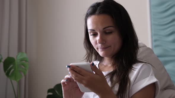 Happy Young Woman Holding Smart Phone Looking at Cellphone Screen Enjoying Using Mobile Apps for
