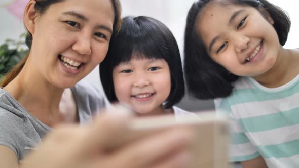 Slow motion Happiness moment at home, Happy Asian family take selfie photo together. alt