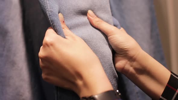 Female Hands choosing to buy Jeans in shopping mall. Touch and catch with jeans.