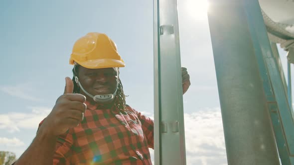 African Black Man Climbing on the Leders of the Silio System with Humbs Up alt