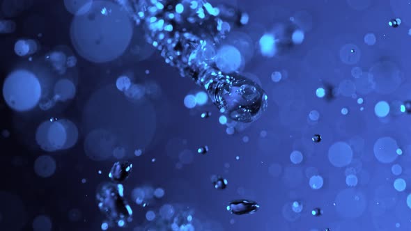 Super Slow Motion Shot Flying Water Drops on Blue Gradient Background at 1000Fps. alt