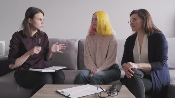  Woman Social Worker Talking To Mother and Daughter Teenage Girl