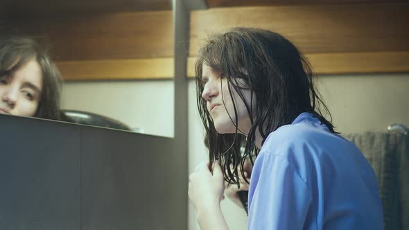 Teen Girl Dries Her Hair with a Hairdryer After a Shower