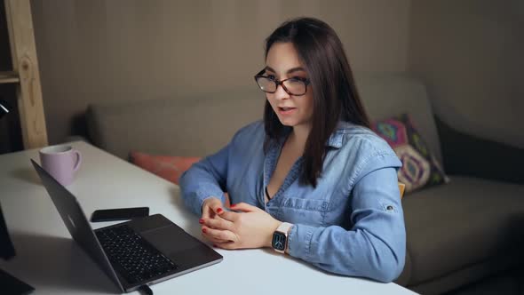 Young Woman During Online Conference Talking to Colleagues Using Streaming App on Laptop alt