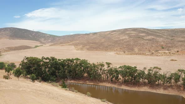Pond Surrounded by Trees and Down a Hill alt