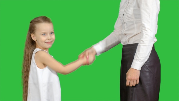Daughter and mother hand shake on a Green Screen, Chroma Key