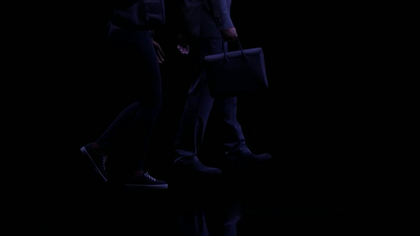 Businessman and Young Woman Walking Together at Night