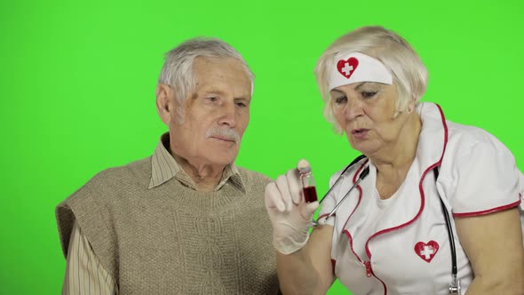 Mature Woman Nurse Doctor Examines Senior Patient Man with Problems alt