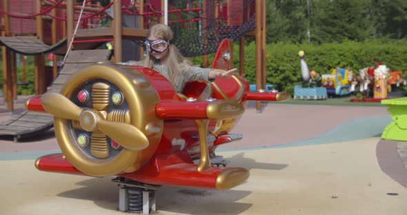 Happy Preschool Girl in Pilot Goggles Rocking on Spring Toy Plane ...