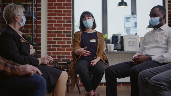 Sad Woman Crying at Aa Therapy Meeting in Front of Group of People During Covid 19 Pandemic alt