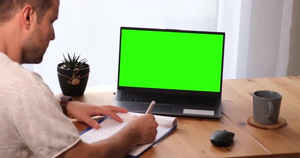 Man Taking Notes With Personal Computer With Mock Up Chroma Key Display