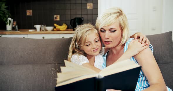 Mother Reading Book To Daughter