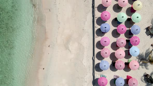 Beautiful clear sea water,sandy beach and multicolred sunshades during sunny day in Gili Trawangan. alt