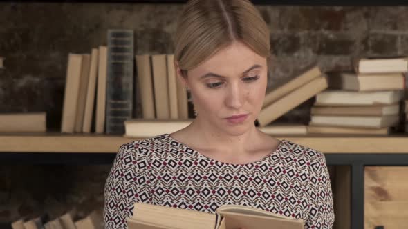 Close up of the Caucasian young beautiful woman student in glasses reading a book alt