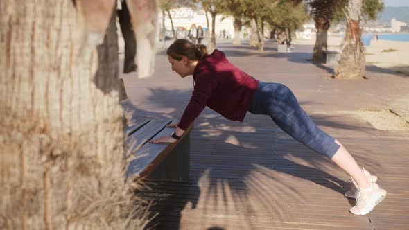 Young Sporty Woman Doing Push Ups Exercise Outdoor alt
