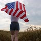 Patriotic Young Woman Holds the US Flag and Runs Across the Field - VideoHive Item for Sale