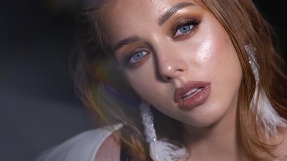 Blonde Model with Bright Evening Makeup. Beauty, Fashion. Girl Posing in Studio with Beautiful