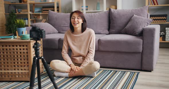 Slow Motion of Cute Young Lady Vlogger Talking Gesturing Recording Video at Home alt