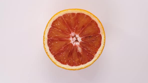 Fresh Cutted Red Orange Spinning on White Background Top Down View alt