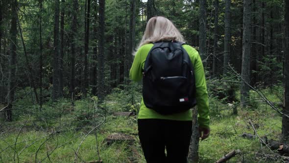 Woman tourist walking through the forest