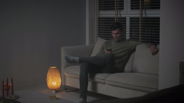 Man browsing his phone at night