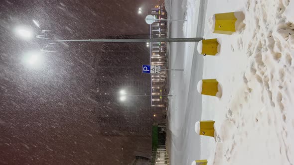 Snow Plow Tractor Removes Snow From the Roadway in the Parking Near Huge Shop Mall Lot While There