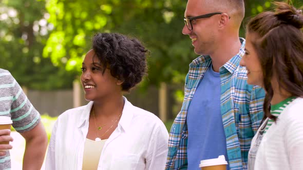 Happy Friends Drinking Coffee and Talking in Park  alt