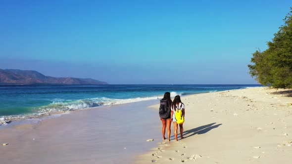 Girls enjoying life on beautiful bay beach holiday by shallow ocean with white sandy background of G alt